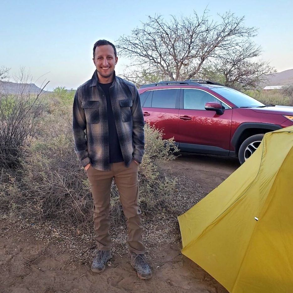 Ryan standing by tent